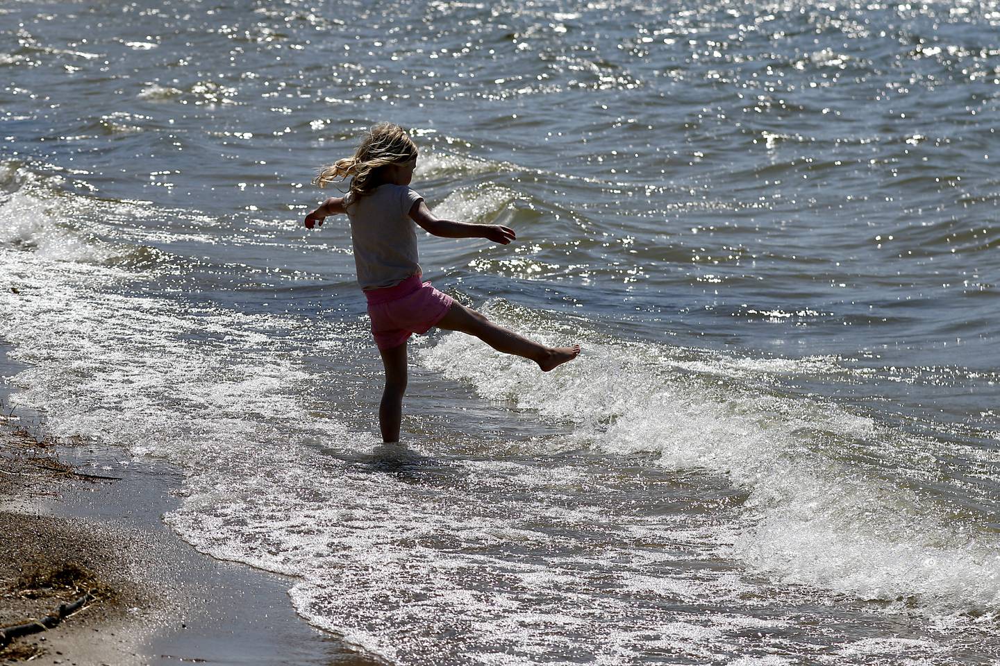 Mila Keller, 5, of Crystal Lake plays in the water Wednesday, April 12, 2023, as she enjoys an unseasonable warm day at Crystal Lake’s Main Beach.