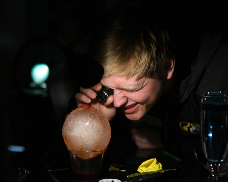 Seth Swanson of Elmwood Park High School takes a closer look at an ice ball as color die and salt was poured over it to see how ice reacts during the Climate of Inquiry portion of The Climate of Hope Conference of 2024, held at Downers Grove North High School on Friday March 1, 2024.