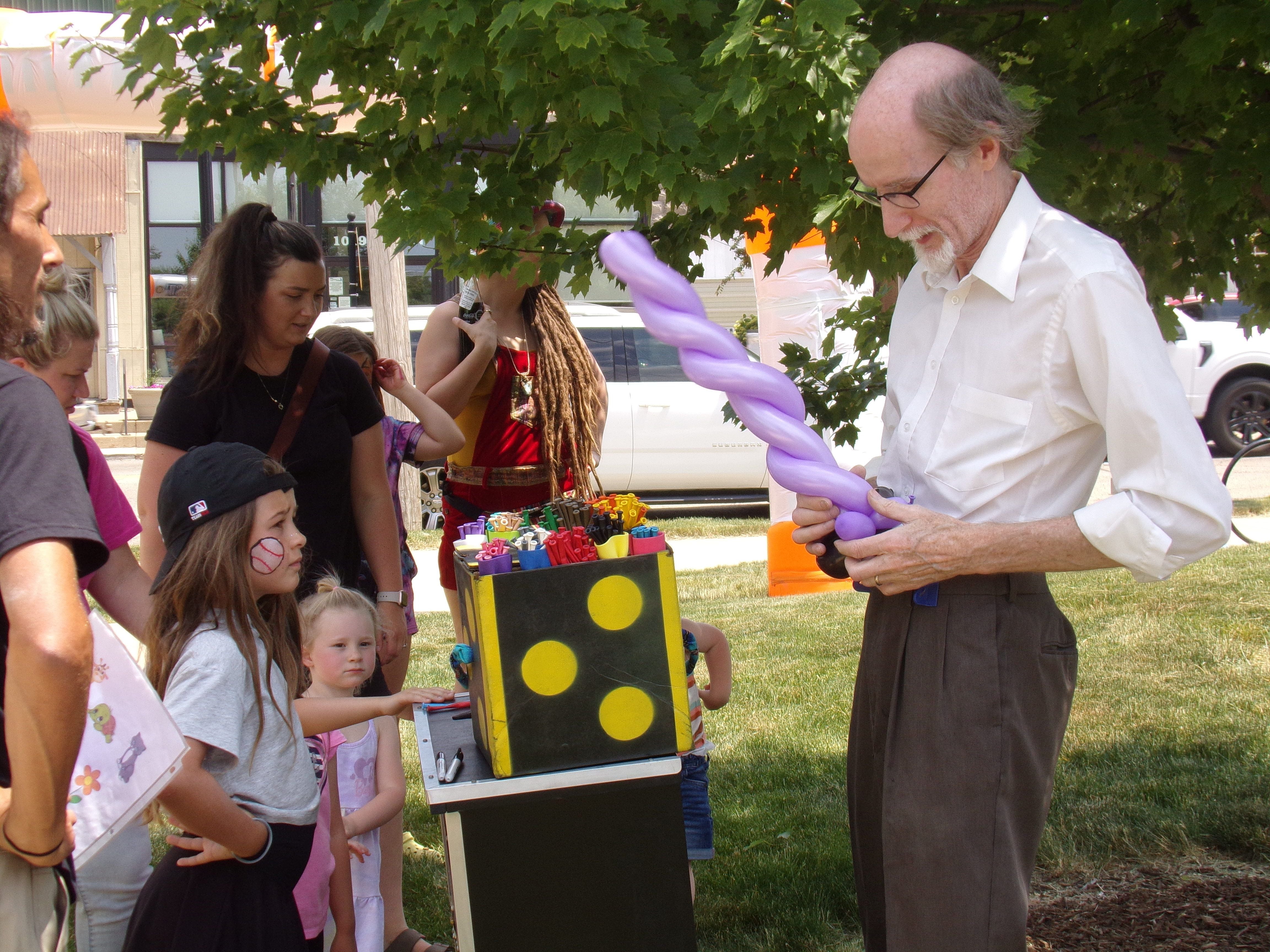 Mr. Cinnamon makes balloons for children Saturday, June 3, 2023, during the Shrimp and Brew Hullabaloo at Rotary Park in Princeton.