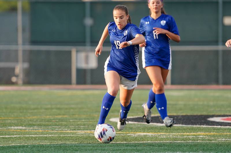 Geneva’s Evyn Schokora (19) moves the ball up the field against Glenbard East during a Class 3A Glenbard East Regional semifinal soccer match at Glenbard East High School in Lombard on Tuesday, May 14, 2024.