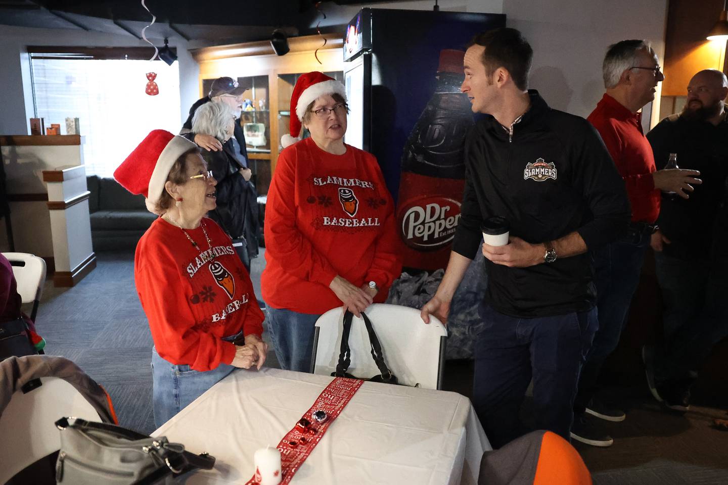 Slammers season ticket holders Sharon Bielfeldt, left, and Donna Kovak talk with new owner Night Train Veeck at the Joliet Slammers annual Holiday Open House on Saturday, Dec. 2 at Duly Health and Care Field in Joliet