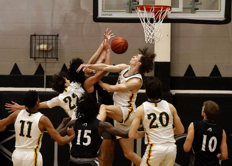 Crystal Lake South's Tony Santarelli (left)  and Crystal Lake South's James Carlson  (right) sandwich Kaneland's Evan Frieders as he drives to the basket during the IHSA Class 3A Kaneland Boys Basketball Sectional championship game on Friday, March 1, 2024, at Kaneland High School in Maple Park.