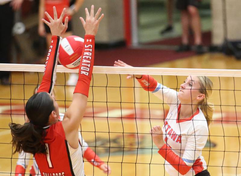 Ottawa's Ella Schmitz has her spike blocked by Streator's Aubrey Jacobs on Thursday, Aug. 29, 2024 in Kingman Gym at Ottawa High School.