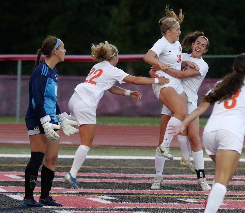 Crystal Lake Central's Olivia Anderson (left)  and Jillian Mueller (right) Ruch to hug Crystal Lake Central's Brooklynn Carlson after she scores the game tying goal during the Class 2A Deerfield Supersectional girls soccer match against St. Ignatius College Prep on Tuesday, May 28, 2024, at Deerfield High School.