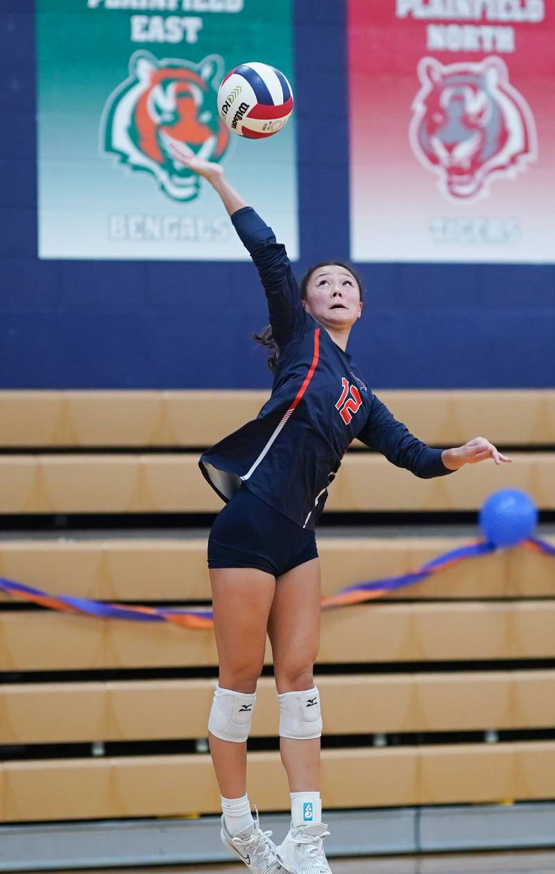 Oswego’s Ava Flanigan (12) serves the ball against Romeoville during a volleyball game at Oswego High School on Tuesday, Oct. 17, 2023.