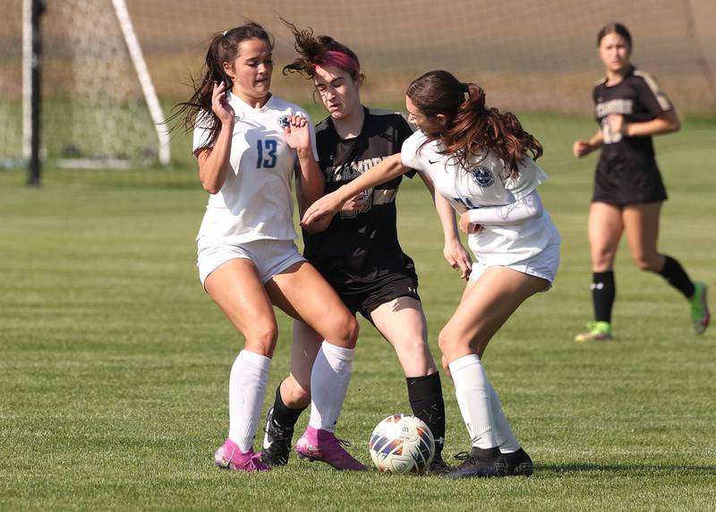 Woodstock's Brooklyn Kentgen (left) and Alyssa Fetzer surround Sycamore's Hannah Raetzke during their Class 2A regional semifinal game Wednesday, May 15, 2024, at Kaneland High School in Maple Park.
