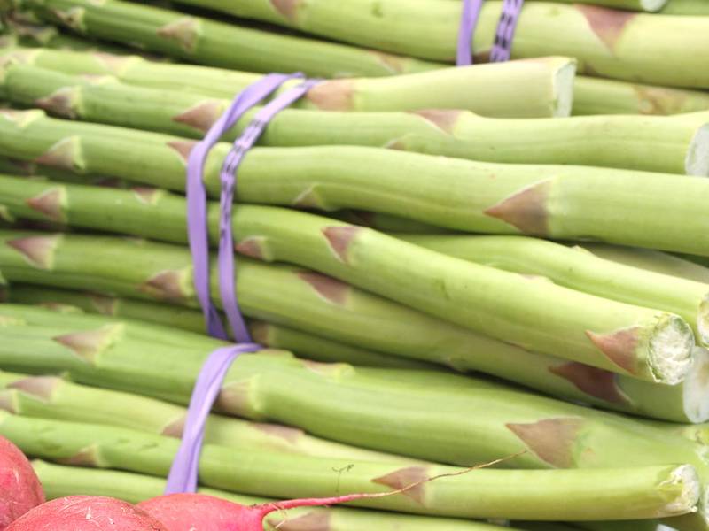 Radishes and asparagus at the Theis Farm Market booth Thursday, June 2, 2022, during the first DeKalb Farmers Market of the season at Van Buer Plaza in Downtown DeKalb.