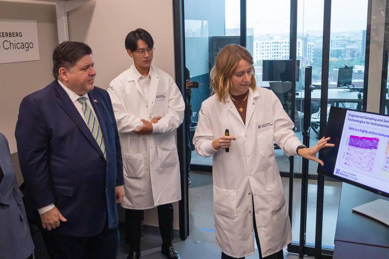 Chan Zuckerberg Biohub Fellow Hope Burks presents her research into inflammation monitoring to Gov. JB Pritzker at a launch event for the Chan Zuckerberg Biohub Chicago.