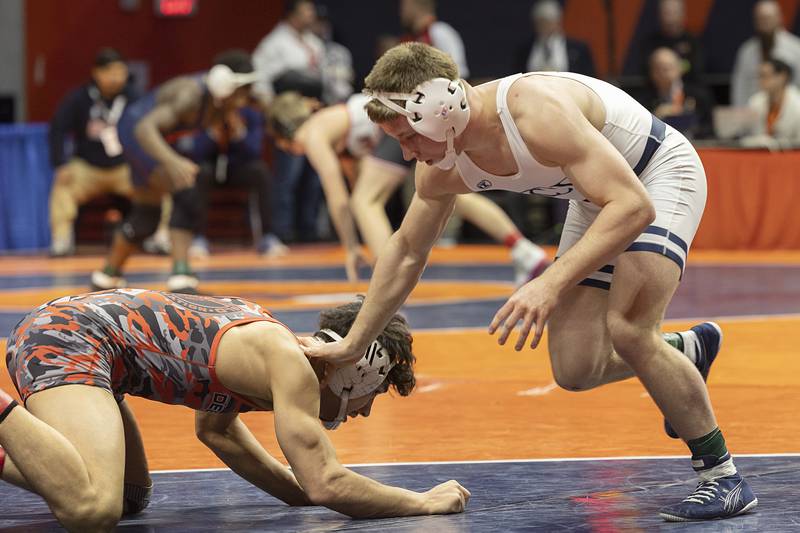 IC Catholic’s Pat Mullen (right) avoids a shot Mark Martinez of Deerfield in the 144 pound third place 2A match Saturday, Feb. 17, 2024 at the IHSA state wrestling finals at the State Farm Center in Champaign.