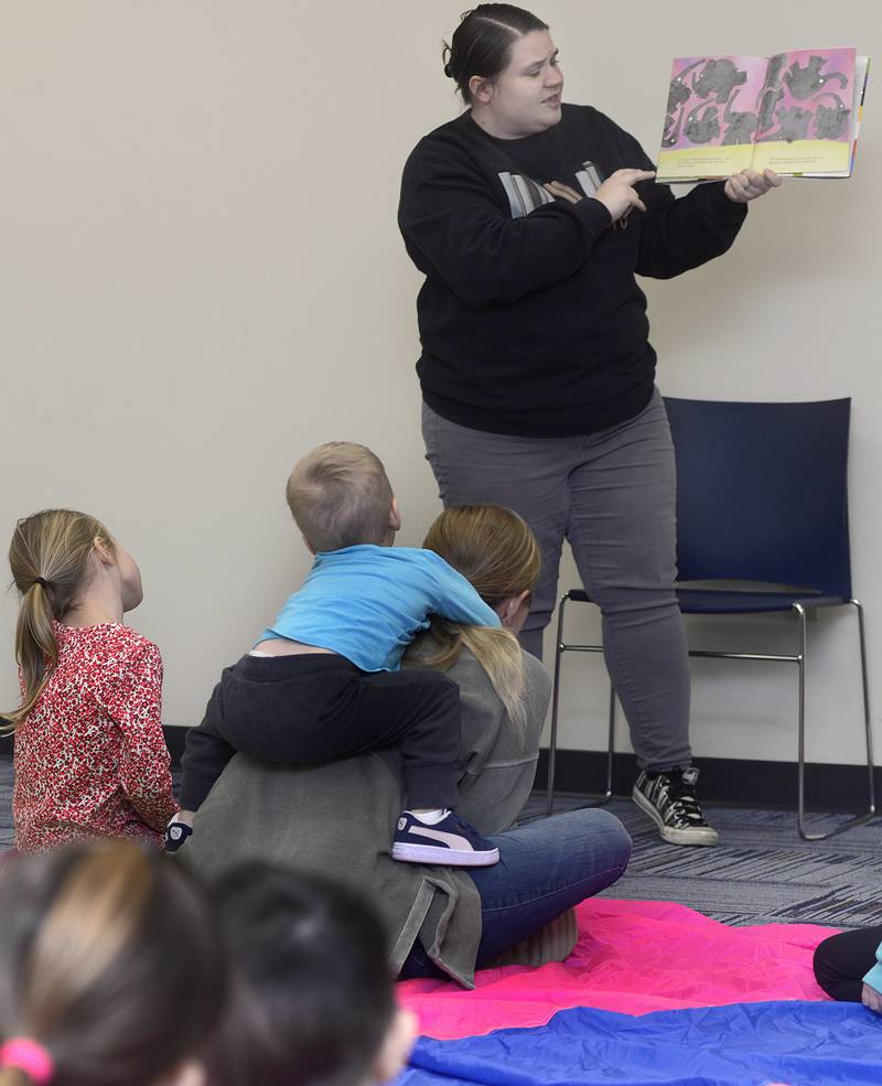 Program Coordinator Ashley Nelson reads a story to children who attended a special Parachute Play event Friday at the Reddick Library in Ottawa.