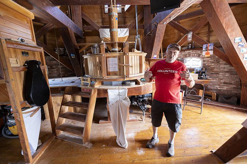 Larry Russell, one 12 active millers at the Fulton windmill, talks about the process of grinding grain into flour Friday, June 7, 2024.