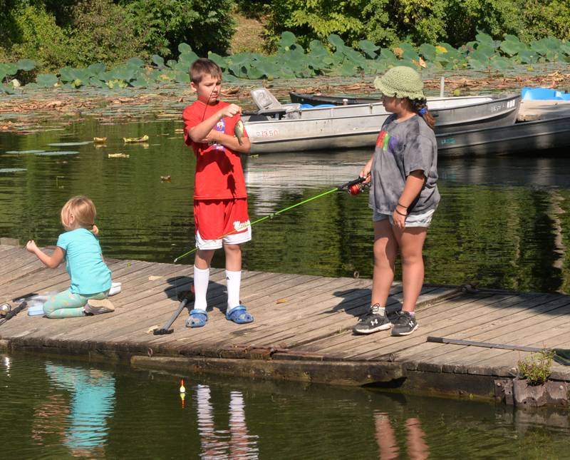 Euryah Wright, 12, of Morrison, hands a fish to Rilee Garcia, 8, of Sterling, during the Whiteside County Sheriff Office and Mounted Patrol's annual fishing derby at Morrison-Rockwood State Park in Morrison on Saturday, Sept. 9, 2023.