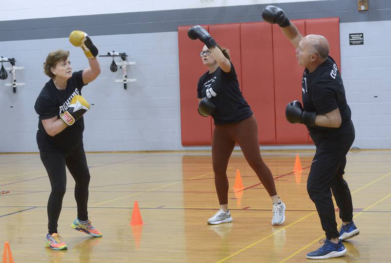 Elaine McKinney goes through drills with instructors Nichole Reynolds and Ken Beutke during her Rocksteady Boxing course at the Streator YMCA.
