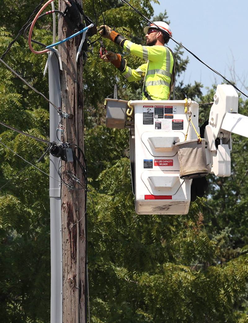 A ComEd employee works on a power line Monday, July 15, 2024, on West Page Street in Sycamore. High Winds and heavy storms hit DeKalb County overnight causing downed trees and power outages in the area.