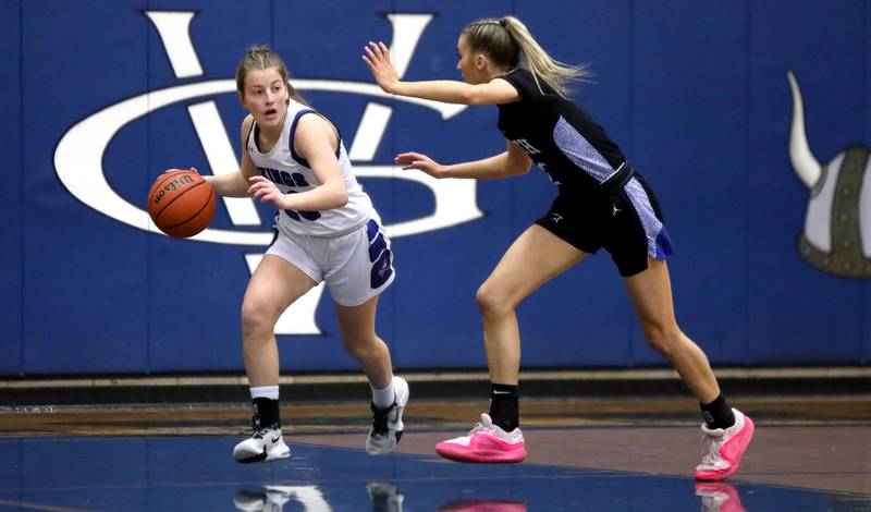 Geneva’s Caroline Madden (left) dribbles the ball away from St. Charles North’s Reagan Sipla during a game at Geneva on Tuesday, Feb. 6, 2024.