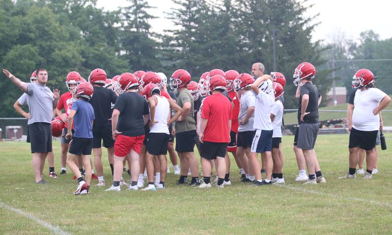 Hall football coach Logan Larson (left) talks to his team during practice on Tuesday, July 9, 2024 at Hall High School. Larson grew up in Springfield and played his first two years of high school at Sacred Heart-Griffin before playing his final two years at Pleasant Plains. He played his freshman year of college at Bowling Green State University. then transferred to SEMO after a coaching change. After college, he coached at Springfield Southeast for three years and spent the last three years at Athens. Larson was the offensive and defensive line coach and special teams coordinator for Athens.