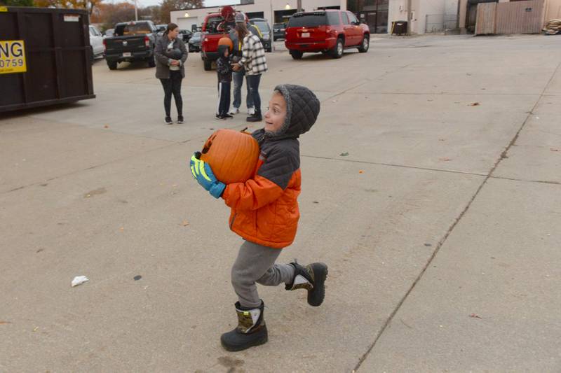 Quixton Lee, 6, of Byron, carries his Jack-O-Lantern to the fire tower for it to be dropped onto the cement during the Byron Fire Department's Pumpkin Smashing Event on Wednesday, Nov. 1, 2023.