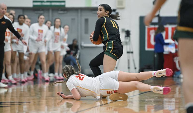 Batavia’s Kylee Gehrt falls on the ankle of Fremd’s Coco Urlacher in the Bartlett supersectional game on Monday, Feb. 26, 2024.