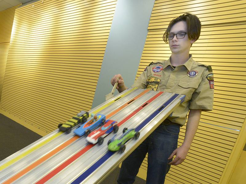 Boy Scout Donovan Maltas starts one of the many races Saturday during the annual Scouting Pinewood Derby at the Peru Mall.