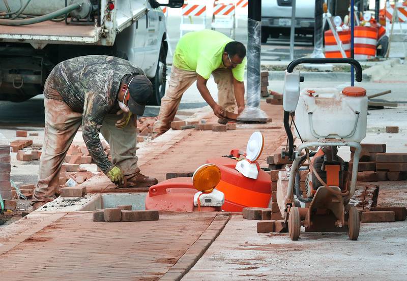 Workers lay bricks on the sidewalk Wednesday, Aug. 28, 2024, as construction continues on Main Street in Genoa.