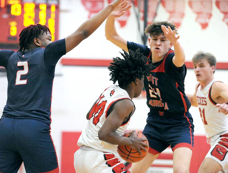 Yorkville's Kaevian Johnson (10) encount tough inside defense from West Aurora defenders Calvin Savage (2) and Gabriel Gonzales (24) during a class 4A regional semifinal basketball game at Yorkville High School on Wednesday, Feb. 21, 2024.