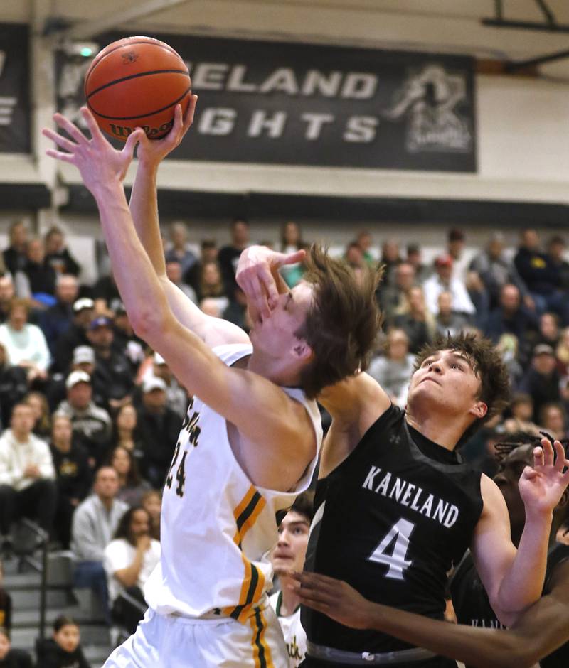 Crystal Lake South's James Carlson is fouled by Kaneland's Preston Popovich as Carlson drives to the basket during the IHSA Class 3A Kaneland Boys Basketball Sectional championship game on Friday, March 1, 2024, at Kaneland High School in Maple Park.