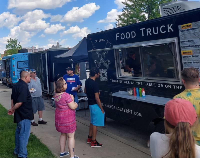 Food truck goers wait for orders, or wait to give their orders Saturday, May 18, 2024, at the Culinary Gangster food truck during the Streator Food Truck Festival.
