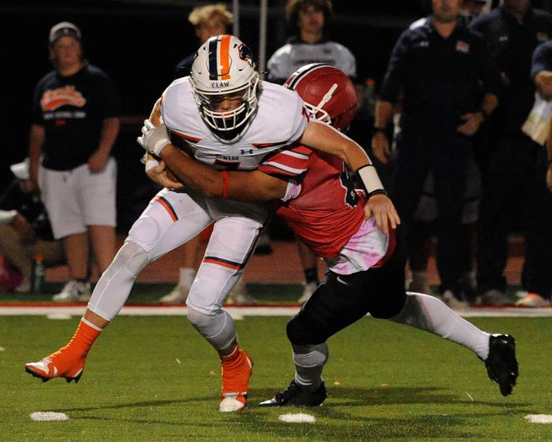 Yorkville defender Jamarion Kenniel (8) sacks Oswego quarterback Brett Connolly (7) on Friday, Oct. 11, 2024, at Yorkville High School.