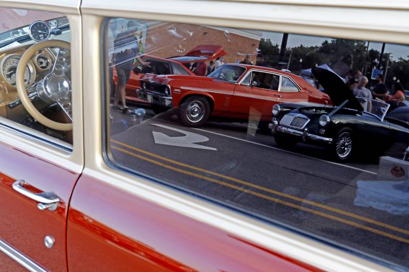 A 1960 MGA is reflected in the window of another car on Wednesday July 10, 2024, during the Cary Cruise Night. The weekly car show hosted by the Cary-Grove Area Chamber of Commerce draws about 125 cars and trucks each week. The event runs weekly on Wednesday through the end of August.