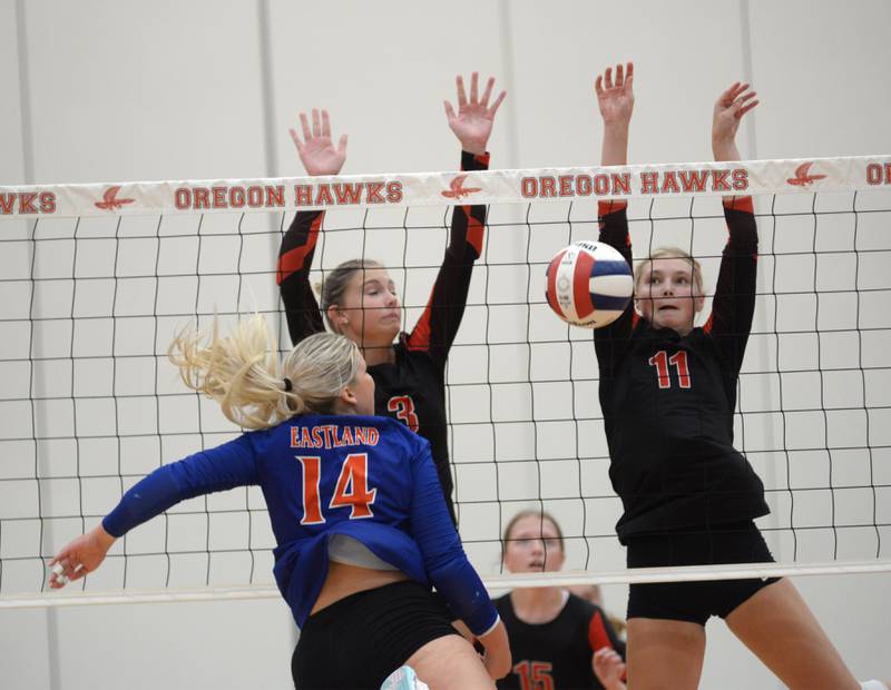 Erie-Prophetstown's Lauren Abbott (11) and Kallie Wiseley (3) block a hit by Eastland's Olivia Klinefelter (14) during a match at the Oregon Volleyball Tournament on Saturday, Sept. 7, 2024.