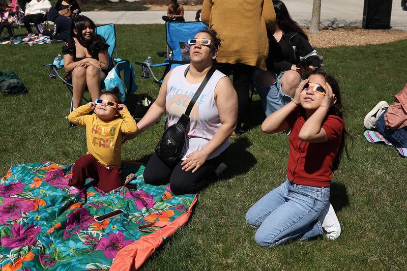 Sinay Barraza watches the eclipse with her children Emilia, left and Tiffany at the Joliet Junior College solar eclipse viewing event on Monday, April 8, 2024 in Joliet.