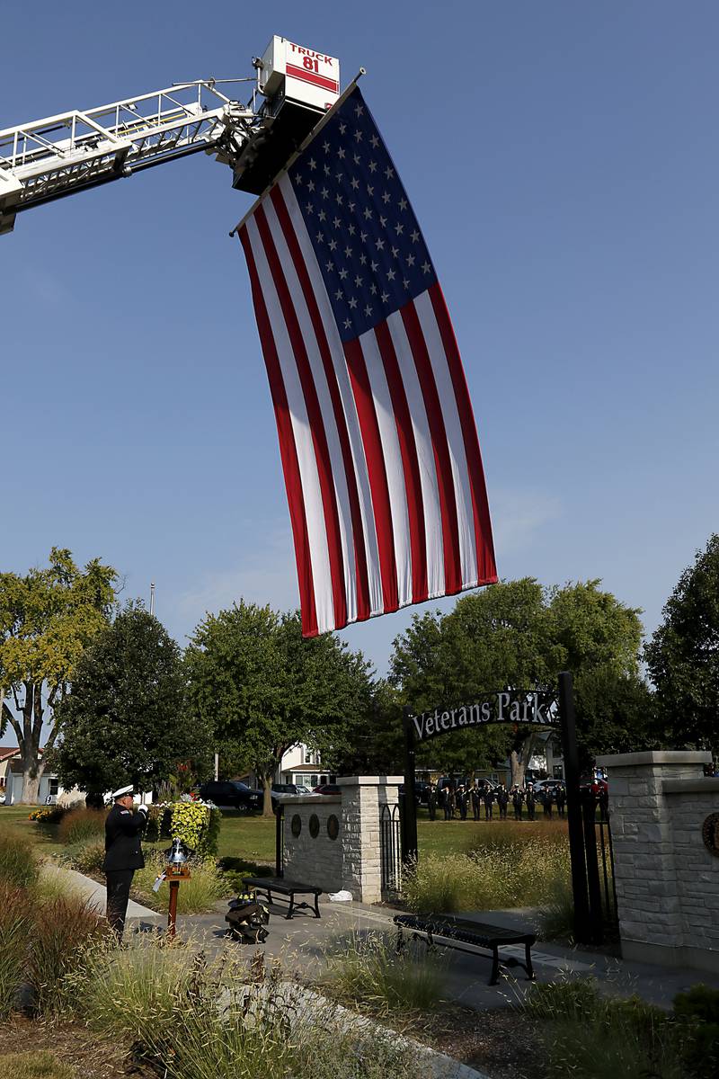 McHenry Fire Protection District Lt. Johnie Downey salutes after ringing the bell to honor firefighters who died during 9/11 at a remembrance ceremony in McHenry on Sept. 11, 2024.