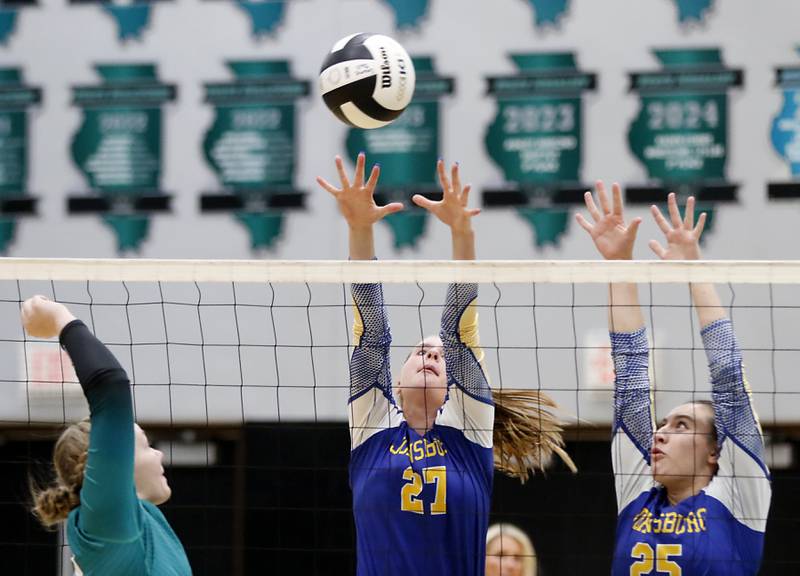 Johnsburg's Adelaide Bruns (center) and Juliana Cashmore (right) try to block the hit from Woodstock North's Devynn Schulze (left) during a Kishwaukee River Conference volleyball match on Wednesday, Sept. 4, 2024, at Woodstock North High School.