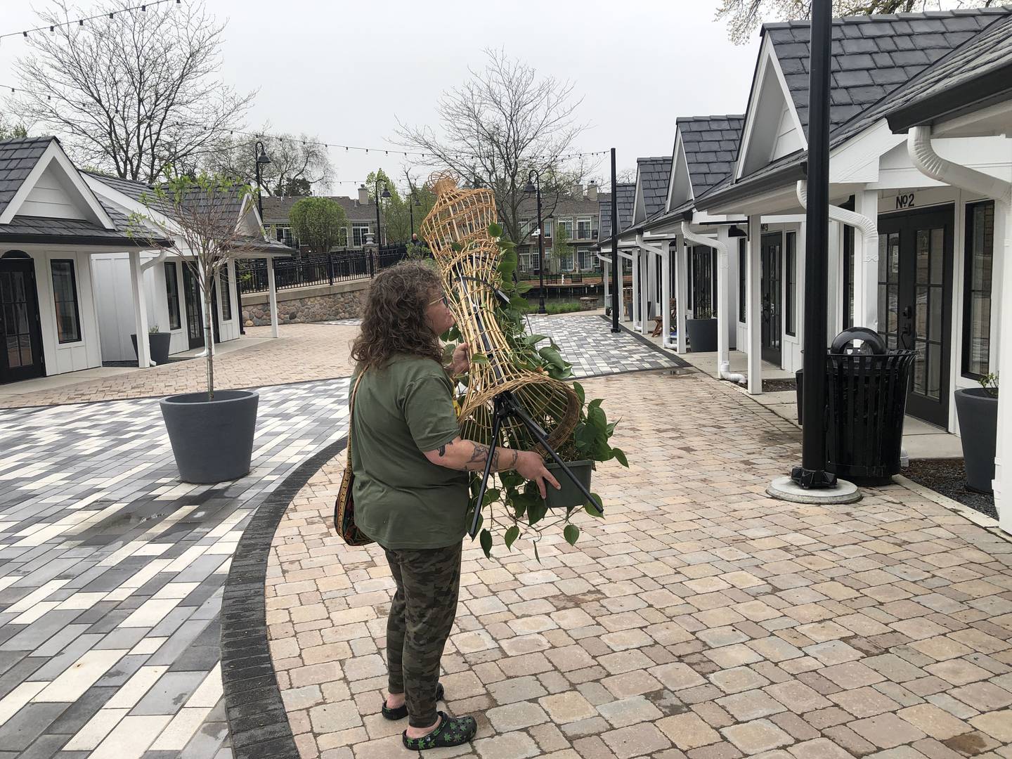 Lori Fisher moves in one of her plants to "merchandise" her store, Preserved Peculiarities, on Sunday, April 28, 2024. The shop is one of the 10 McHenry Riverwalk Shoppes set to open Friday, May 3, 2024.