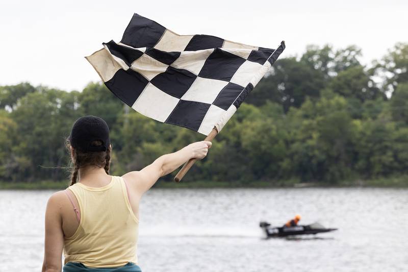 Jessica Conner of Naperville waves the checkered flag at the end of a heat Saturday, August 26, 2023 at the Rock Falls River Chase.