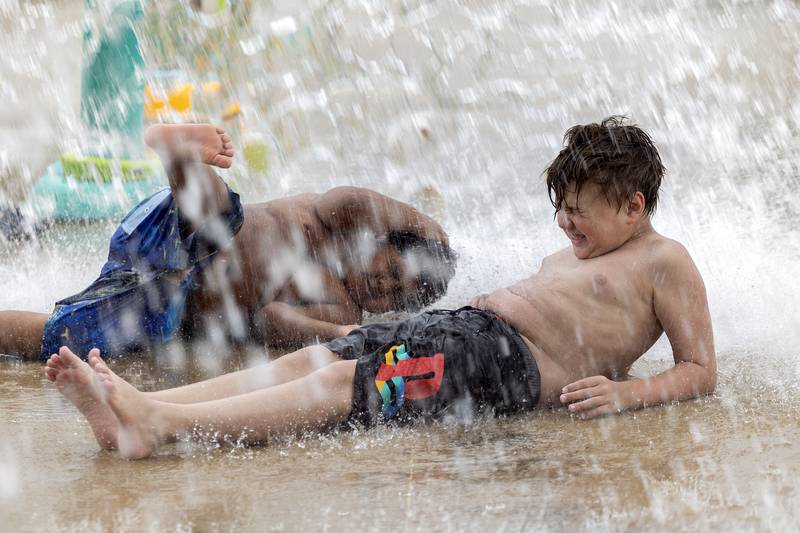 Wes O’Bryant (left), 5, and Andrew Beverage, 5, get deluged with a bucket of water at the Dixon splash pad Wednesday, July 5, 2023. Heat and humidity took the Sauk Valley by storm early this week.