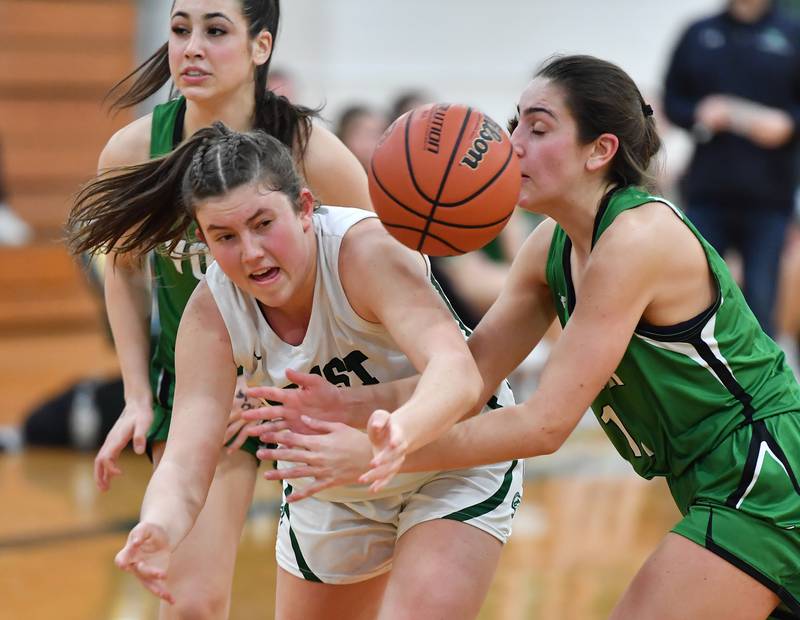 Glenbard West's Makenna Yeager and York's Mia Barton (right) reach for a loose ball during a game on Jan. 22, 2024 at Glenbard West High School in Glen Ellyn.