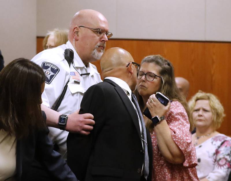 Carlos Acosta tries to kiss his wife, Lori, as he is taken into custody on Thursday, June 6, 2024, after Lake County Judge George Strickland sentenced Acosta, a former Illinois Department of Children and Family Services employee, who was found criminally guilty for mishandling the case of AJ Freund before the Crystal Lake boy was killed by his mother, to six months in jail and 30 months of probation.