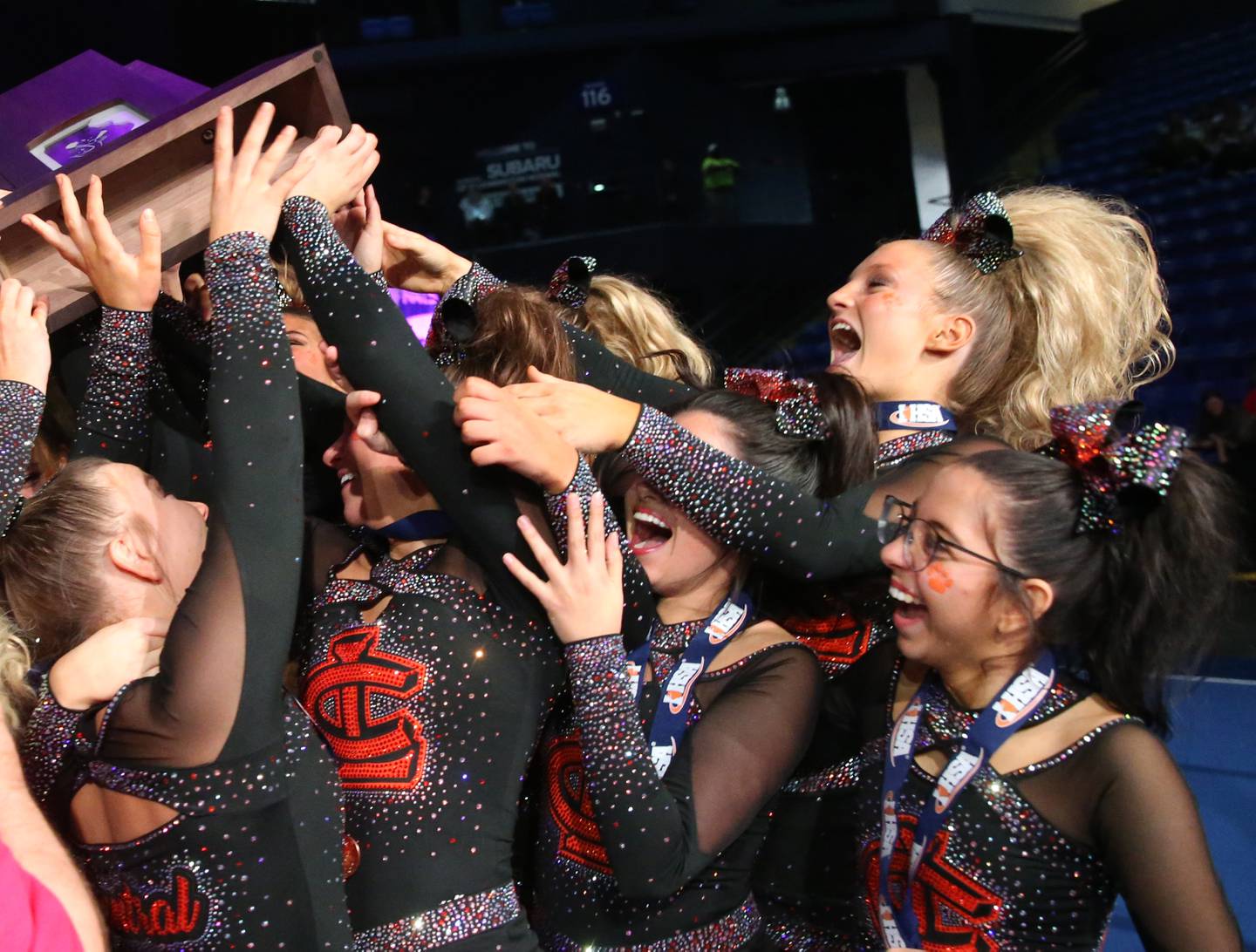 Members of the Crystal Lake Central cheerleading team hoist third-place trophy in the medium team Competitive Cheerleading State Final Competition on Saturday, Feb. 3, 2024 at Grossinger Motors Arena in Bloomington.