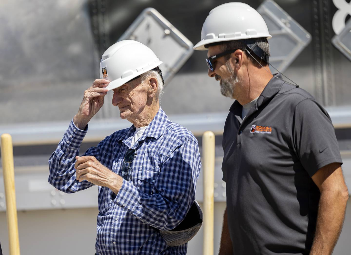 Bob Bonnell, father of Bonnell Industries owner Joe Bonnell (right), slips on a hard hat for the official groundbreaking Wednesday, August 30, 2023 of a new facility in Dixon.