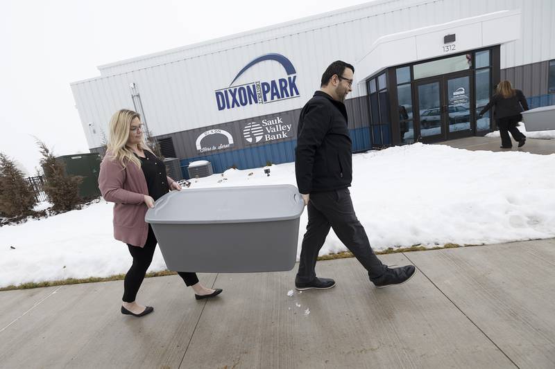 Sauk Valley Bank’s Amy Dewey and Jesse Arellano carry in one of two totes of snacks donated to the Dixon Park District on Thursday, Jan. 25, 2024. The items, which the bank helped collect, will be offered to hungry kids who are using The Facility after school.