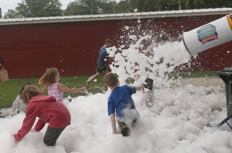 Kids play in a foam machine during  the National Night Out event on Tuesday, Aug. 6, 2024 at Kirby Park in Spring Valley.