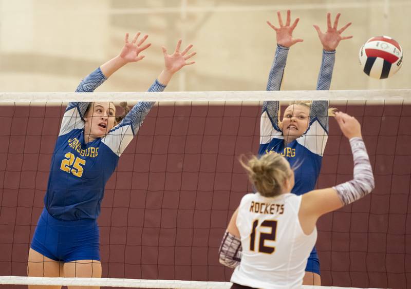 Johnsburg's Juliana Cashmore, left, and Mia Andrle, right, block a shot from Richmond-Burton's Zoe Freund during their game on Monday, August 26, 2024 at Richmond-Burton High School in Richmond.