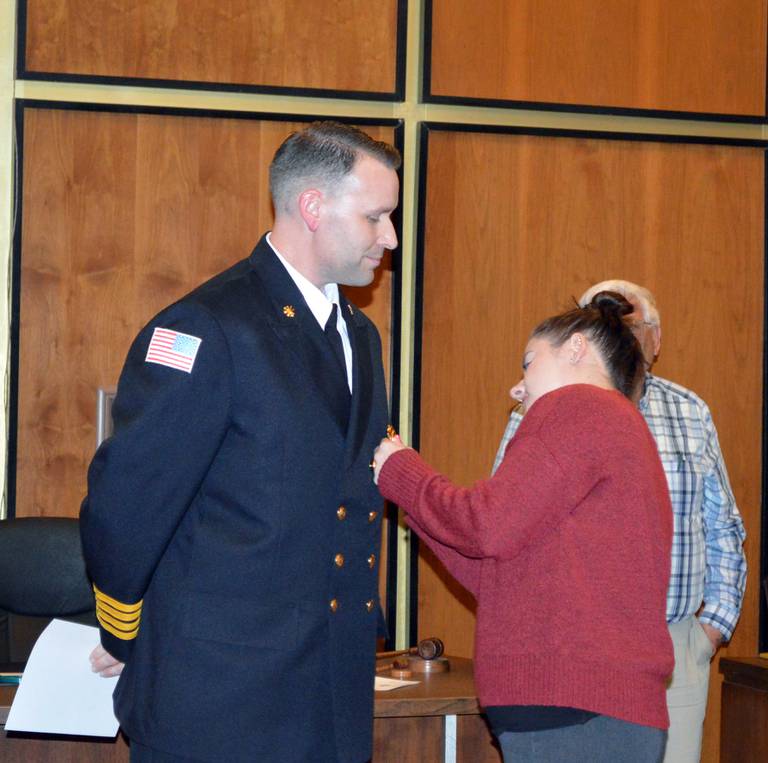 Lauren Sommers, right, pins a badge on her husband, Kyle Sommers, after he was sworn in as Rock Falls Fire Department deputy fire chief during the Tuesday, March 5, 2024, Rock Falls City Council meeting.