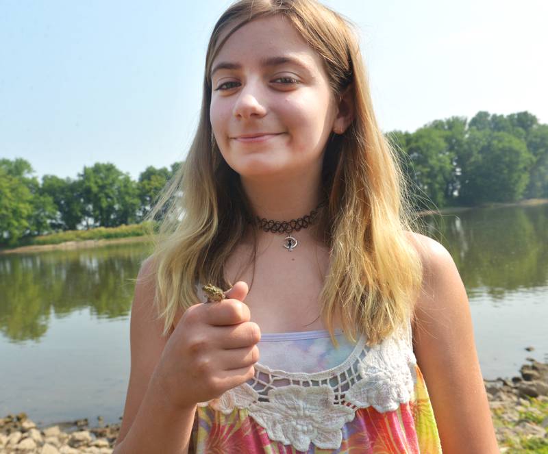 Scarlett Diaz, 11, of Prophetstown holds a little frog as she caught at the 17th Dick Brown Fishing Derby for kids at Prophetstown State Park on Saturday.