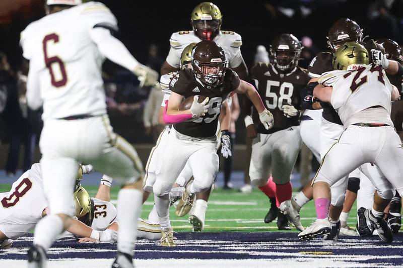 Joliet Catholic’s Keegan Farnaus skips through a hole against St. Ignatius on Friday, Oct. 20 in Joliet.