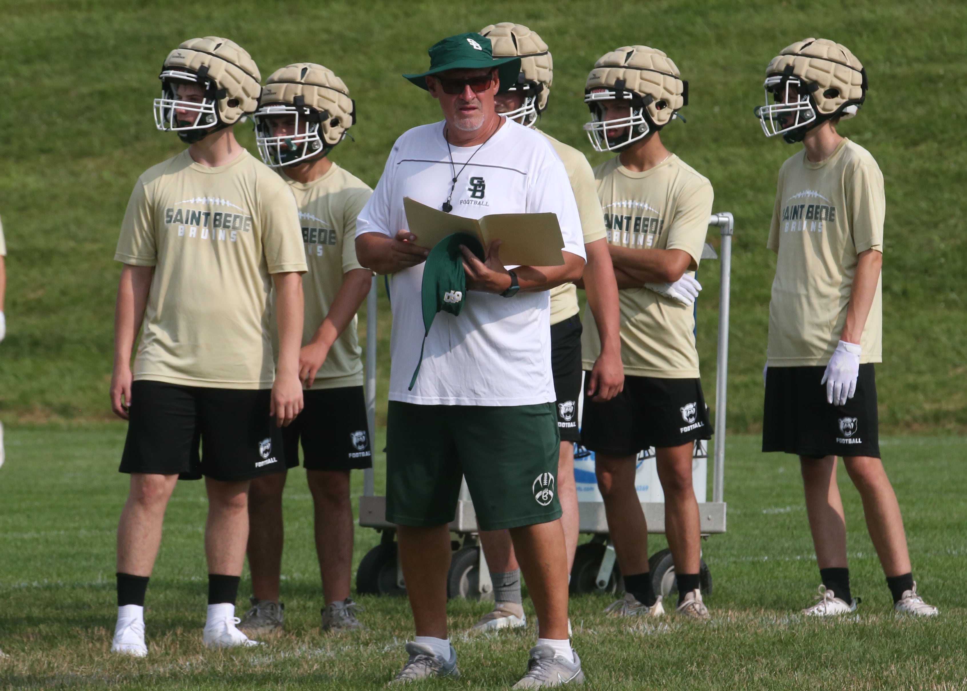 St. Bede football head coach Jim Eustice looks at his playbook during a 7-on-7 meet against Ottawa on Wednesday, July 24, 2024 at Ottawa High School.