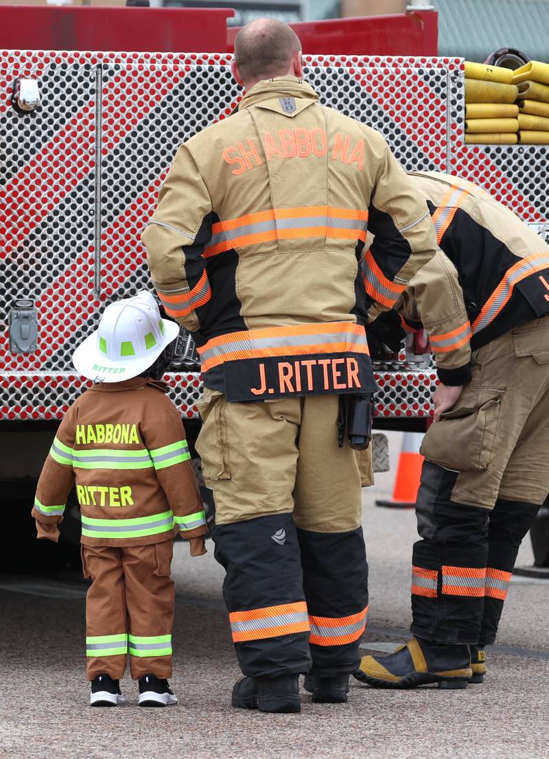 Shabbona firefighters gather behind their truck on DeKalb Avenue in Sycamore Monday, April 1, 2024, before a processional honoring DeKalb County Sheriff’s Deputy Christina Musil. Musil, 35, was killed Thursday while on duty after a truck rear-ended her police vehicle in Waterman.