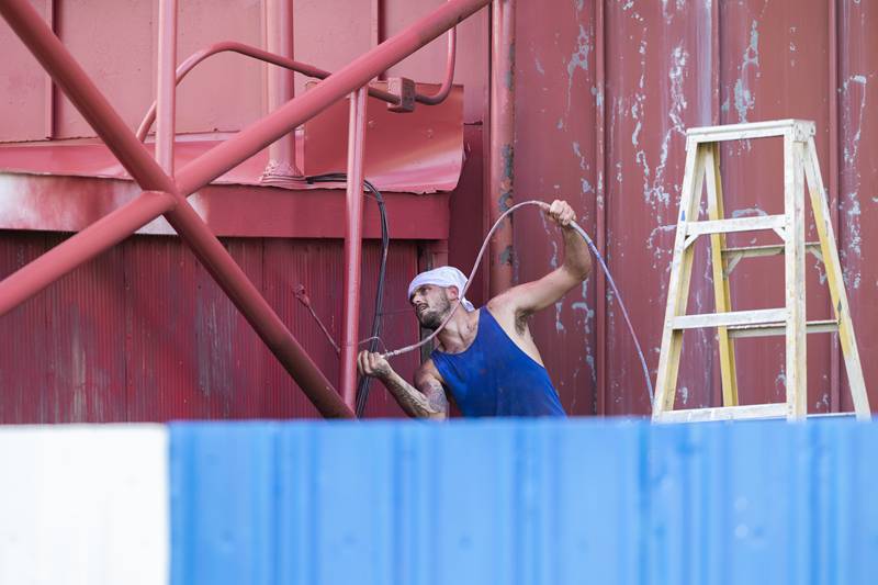 Working for Tucking Painting, Dylan Ingram gives the backside of the Midway Drive-In screen a facelift Tuesday, August 22, 2023. The screen is being gussied up ahead of Labor Day weekend’s showings.