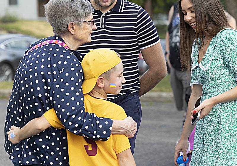 Claudia Nelson hugs Vova Avramenko, 8, Friday, June 30, 2023 while attending Petunia Fest’s Family Fun Night in Dixon. Nelson is the English language tutor of Vova’s mother, both of whom are Ukrainian refugees.